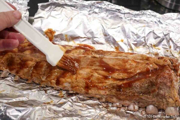 Brushing sauce on the baked ribs.