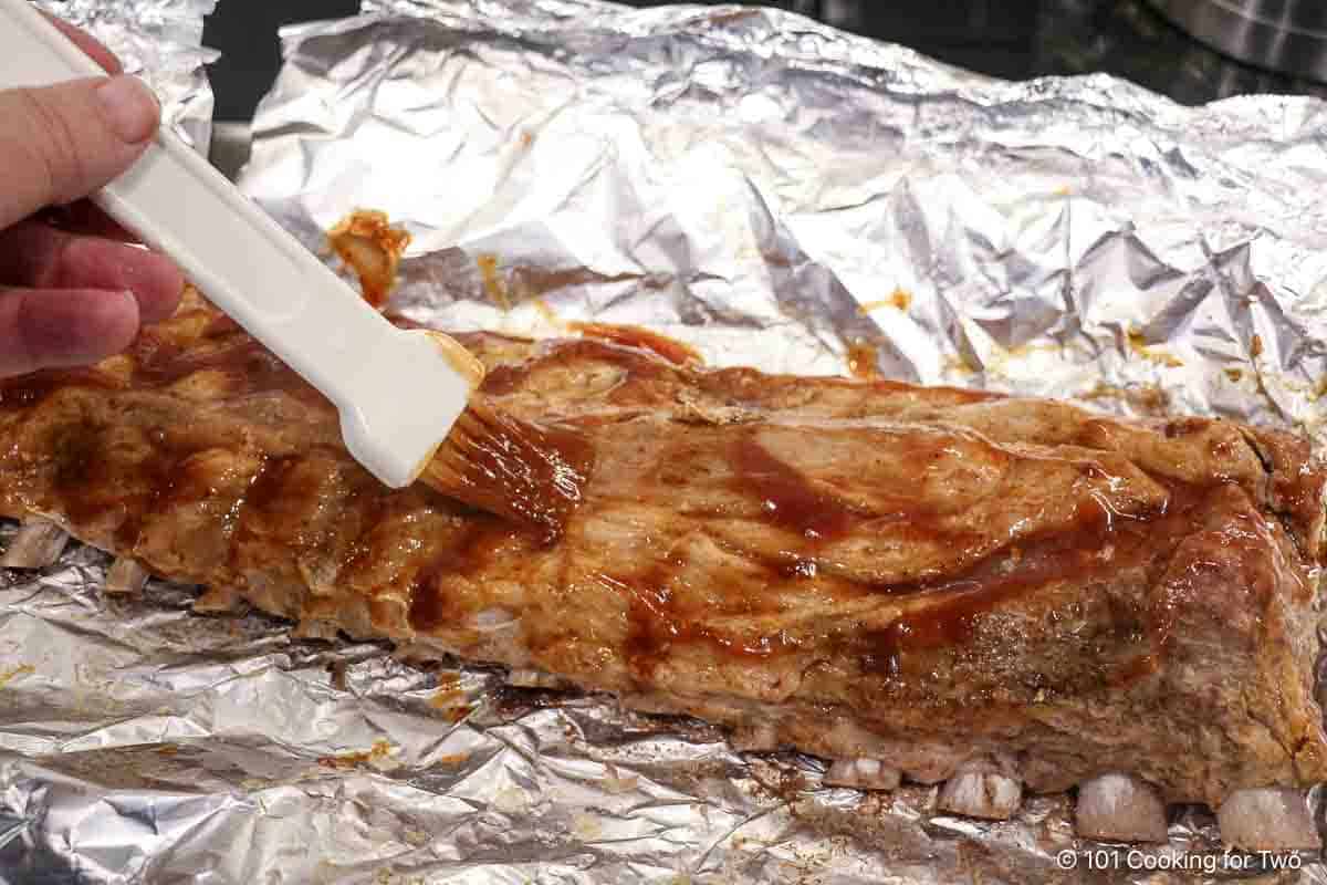 Brushing sauce on the baked ribs.