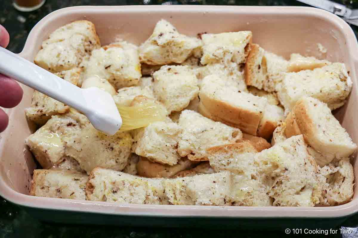 Brushing the casserole with butter.