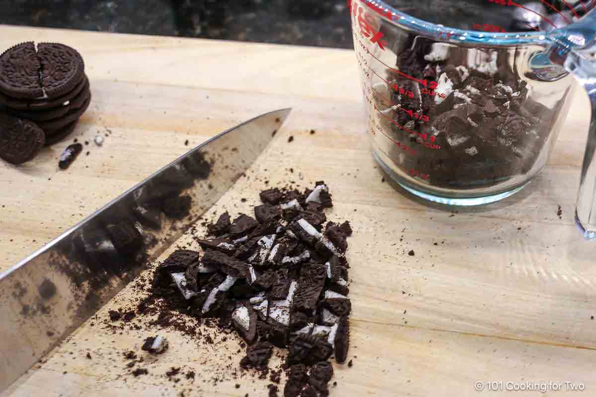 Chopping Oreo cookies with a knife.