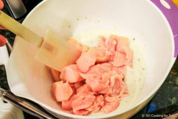 Coating the chicken with breading.