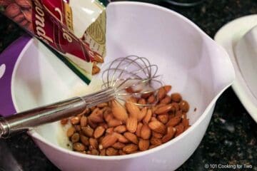 Coating the nuts with the egg mixture.