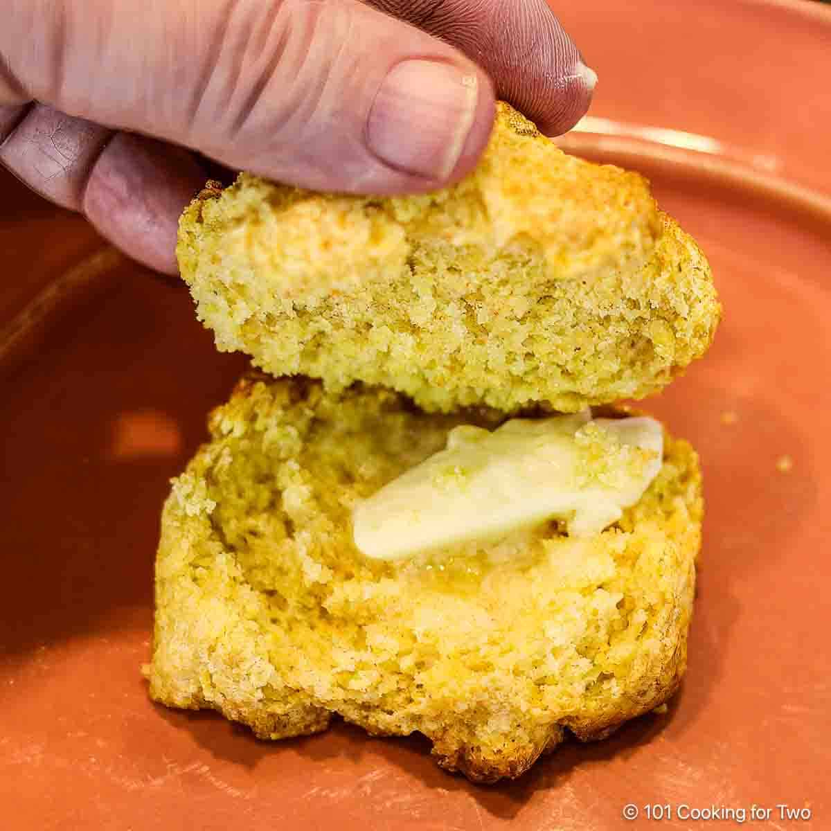 Cornbread biscuit with butter on a plate.