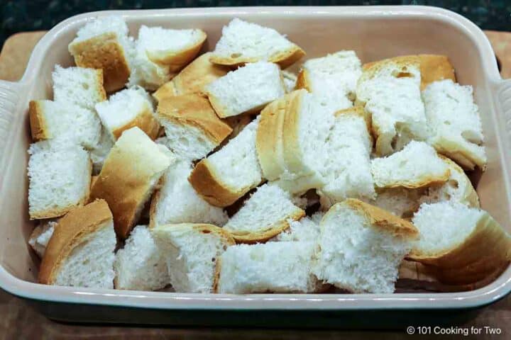 Cubes of bread in a small casserole dish.