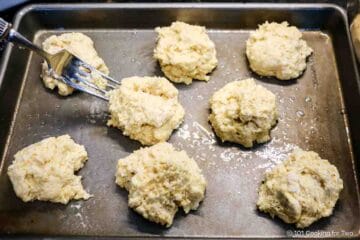 Eight cornmeal drop biscuits on a tray.