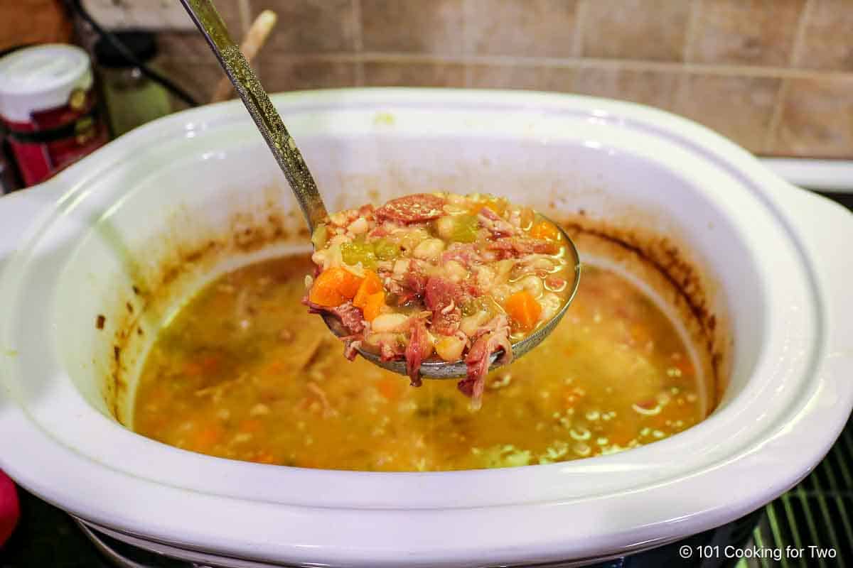 Ham and bean soup in a ladle.