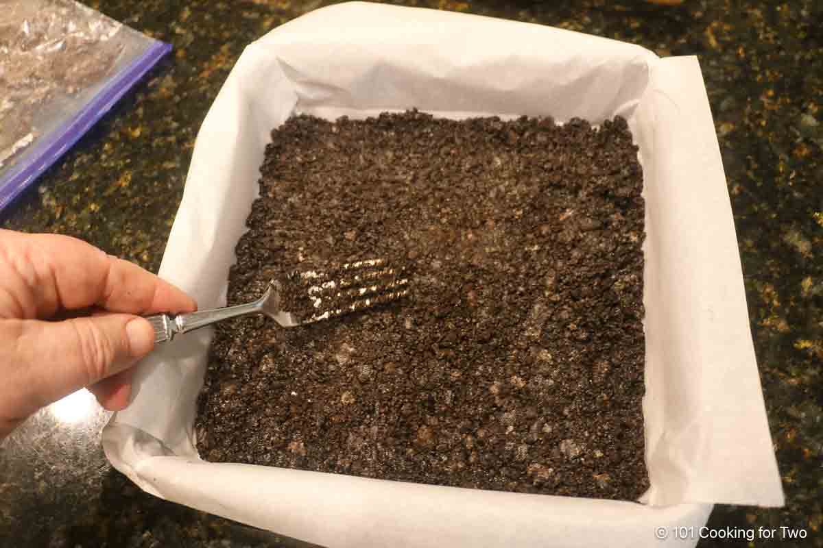 Pressing to Oreo crust into the 9X9 pan.