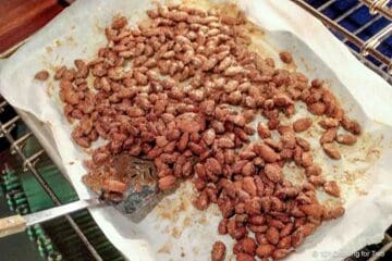 Mixing the nuts on the tray during cooking.