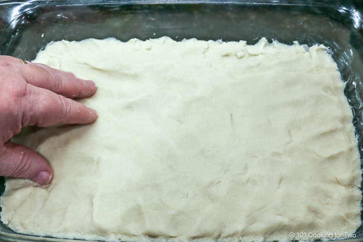 Pressing the crust into a pan.