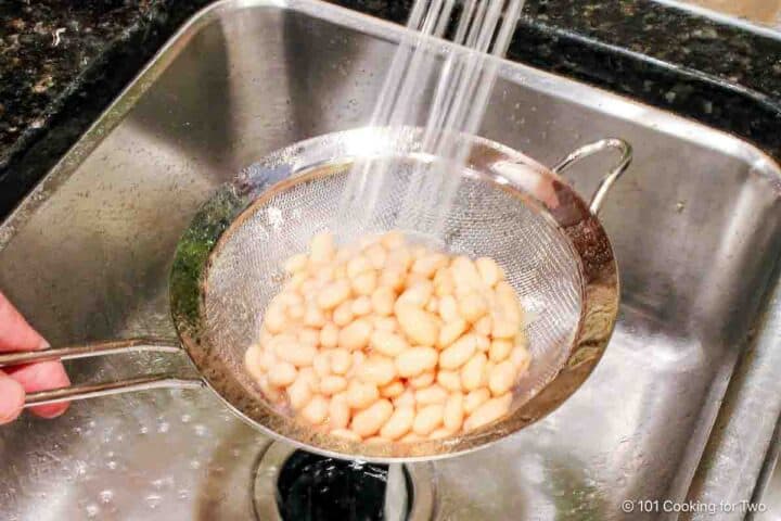 Rinsing beans under running water.