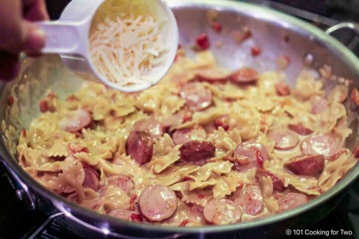 Adding cheese to the casserole.