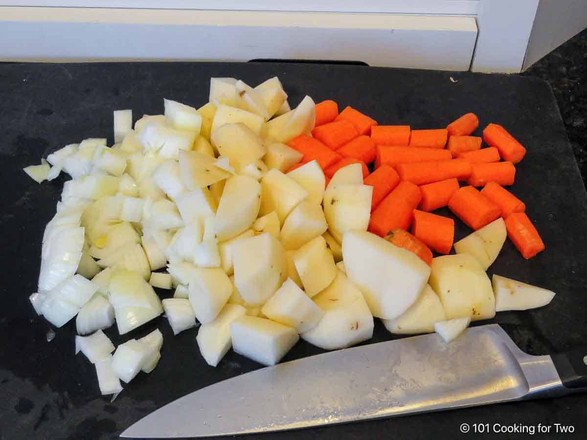 trimmed carrots and potatoes on a board.