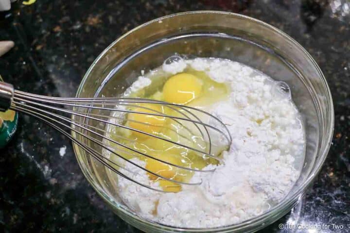 Whisking eggs into the batter.