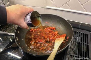 Adding beef broth to the tomato and onion mixture.