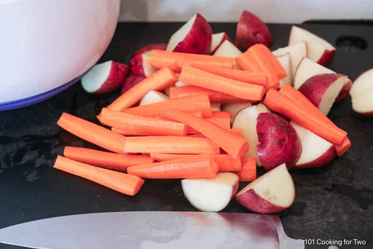 Clean and prep potatoes and carrots.