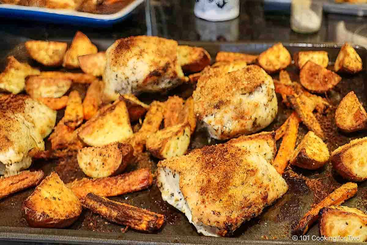 Cooked sheet pan chicken with vegetables.