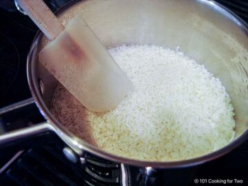 Cooking rice in broth.