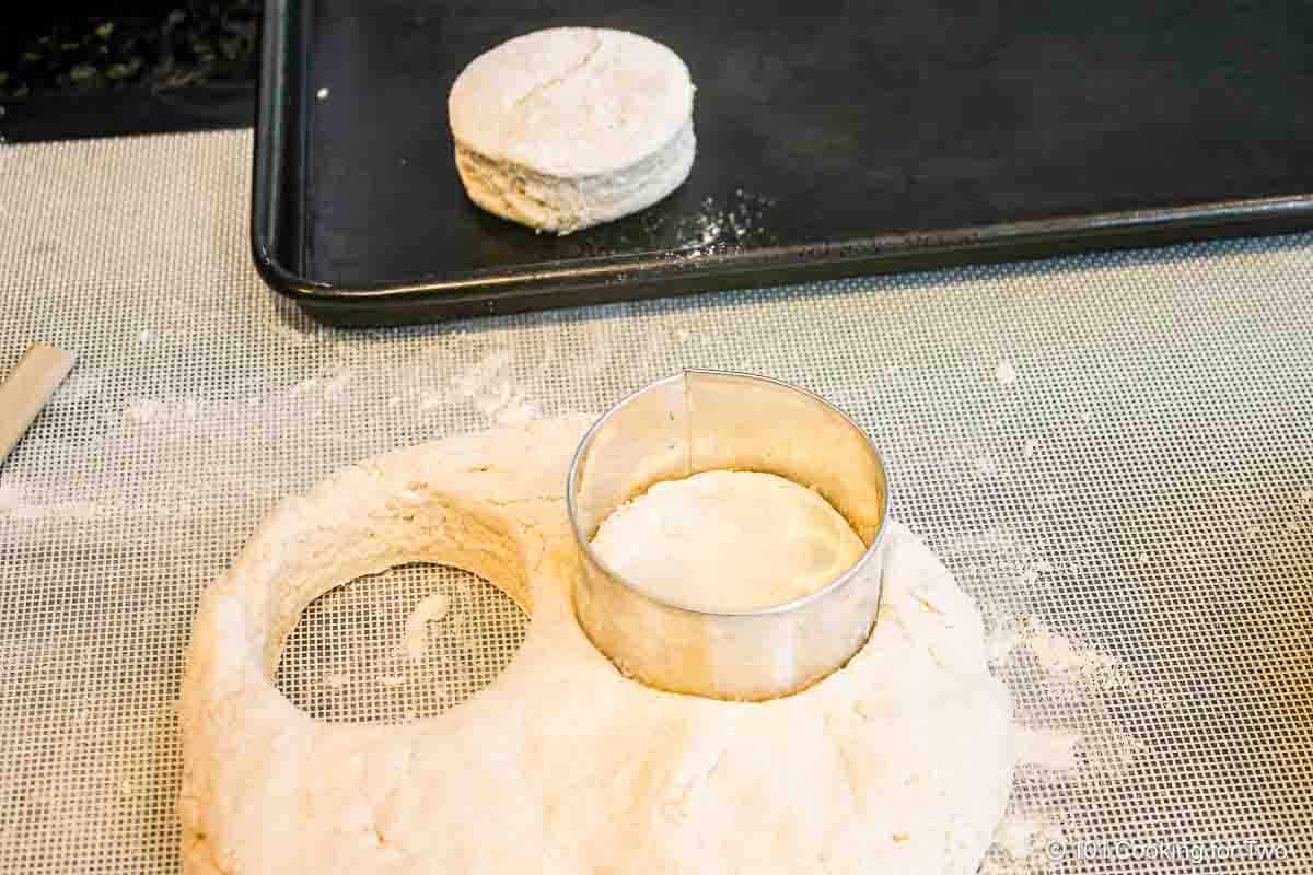 Cutting biscuits and placing them on a baking tray.