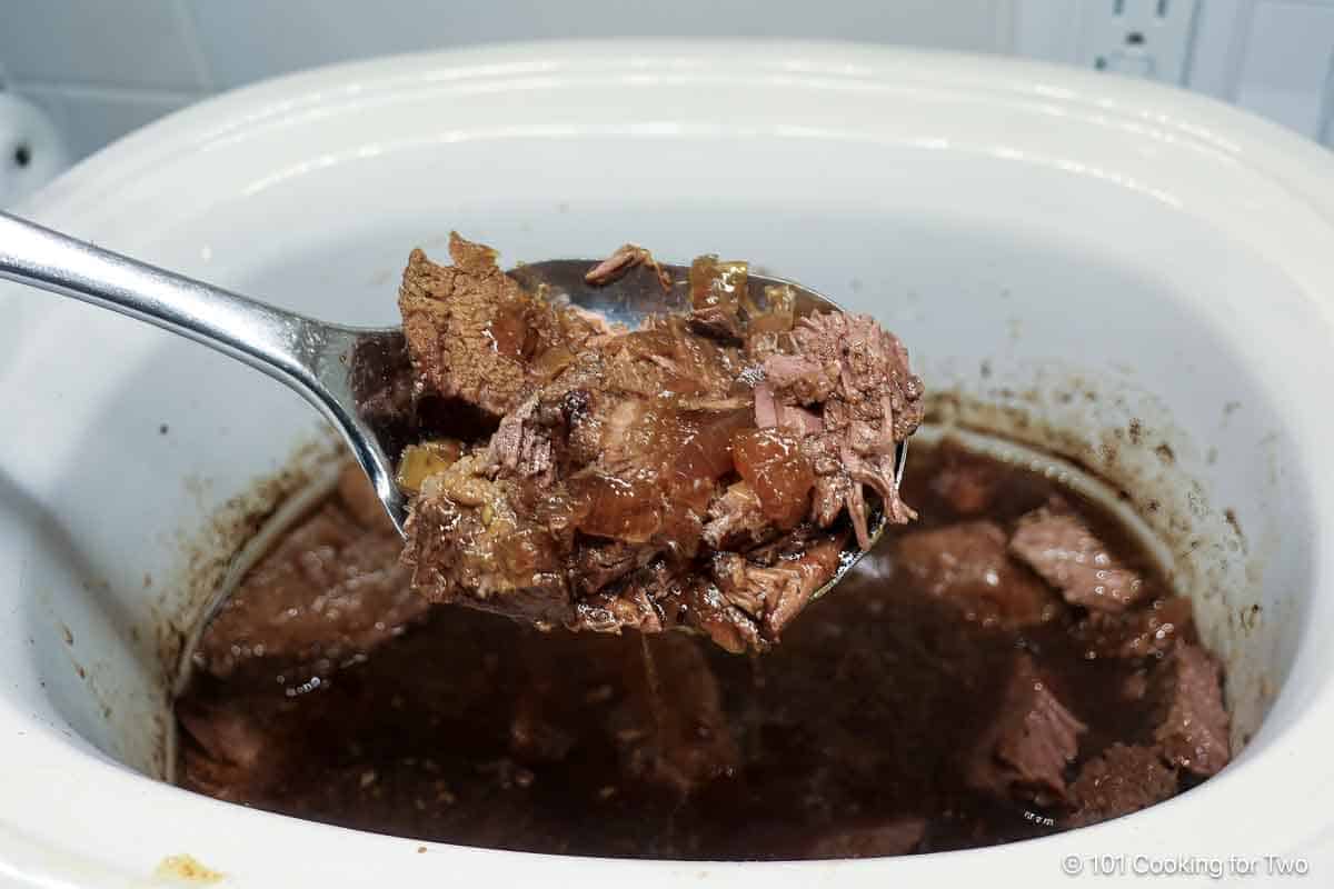 French dip beef in a large spoon.