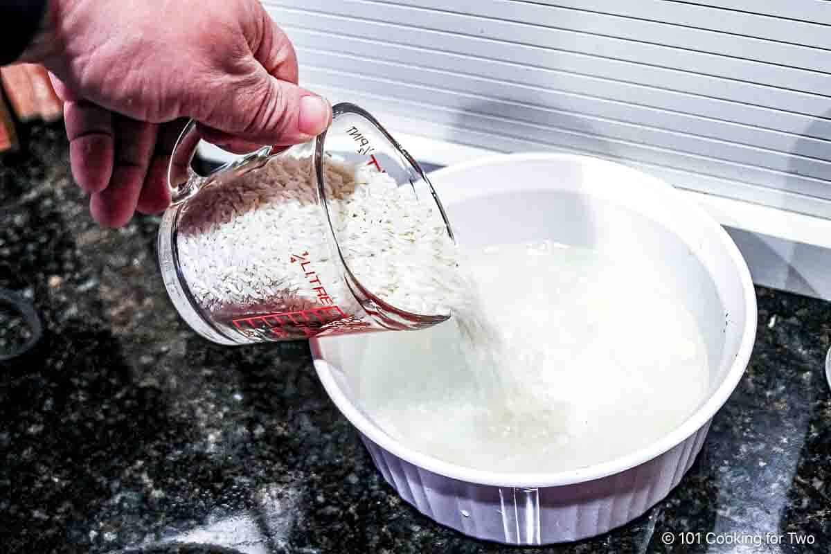 Pouring rice into bowl of hot water.