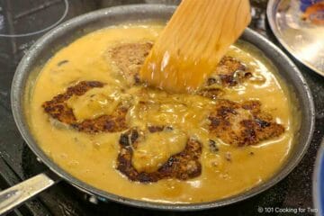 Reheating the patties in the gravy.