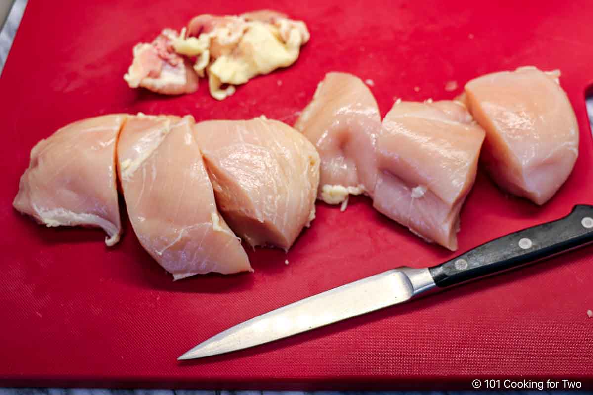 Trimming chicken breasts.