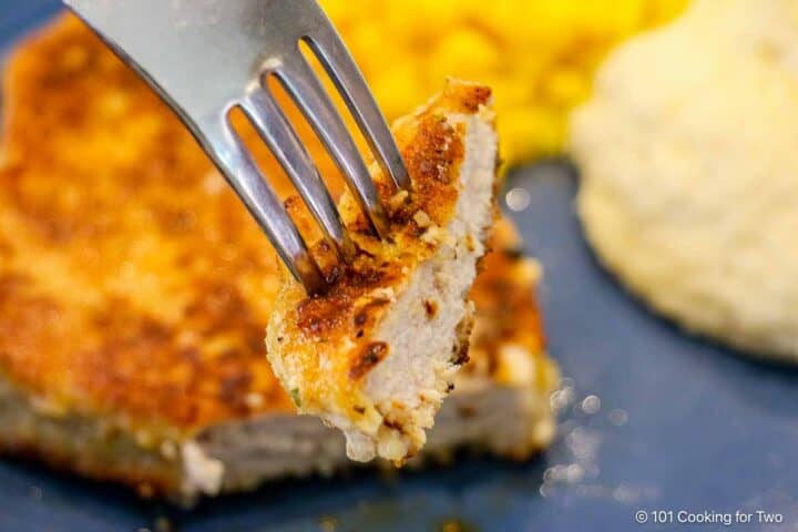 Breaded pork chop on a fork.