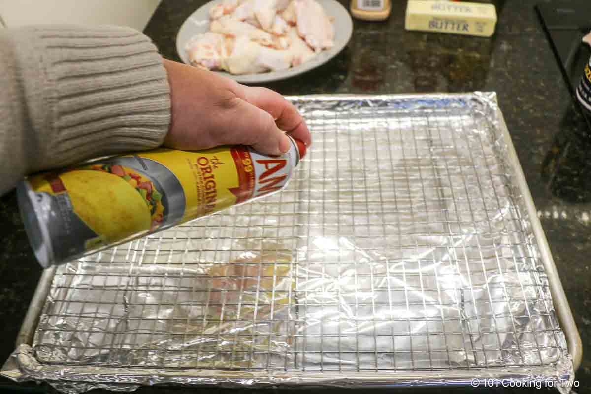 Coating a baking rack with cooking spray.