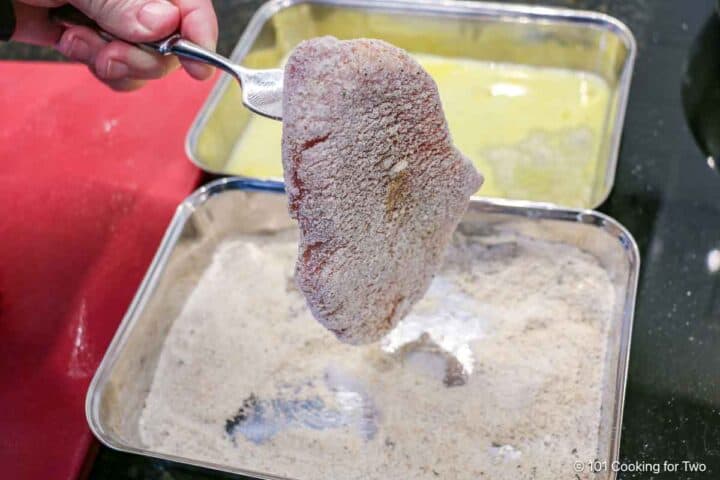 Coating the pork chop with breading.