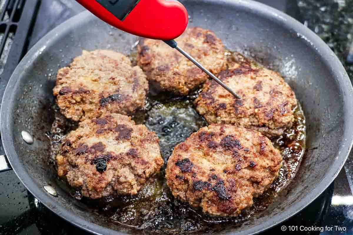 Frying the patties in a skillet.