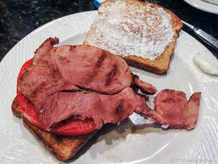 Glazed ham steak on a sandwich.