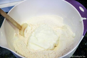 Mixing yogurt into flour mixture with spatula.