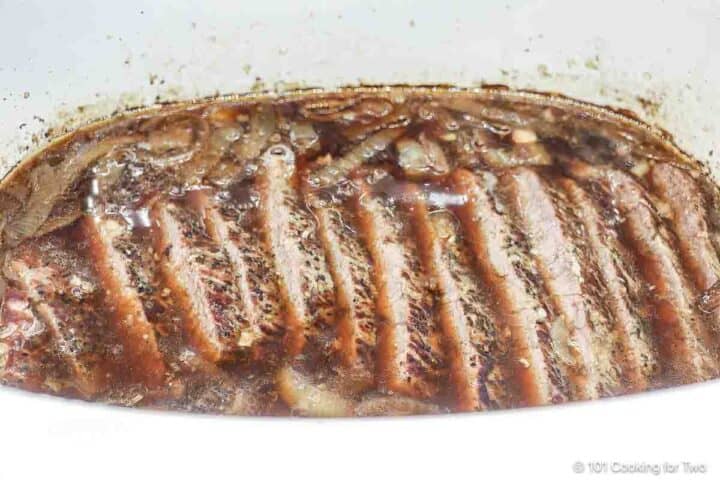 Place the sliced beef into the fluid in the crock pot.