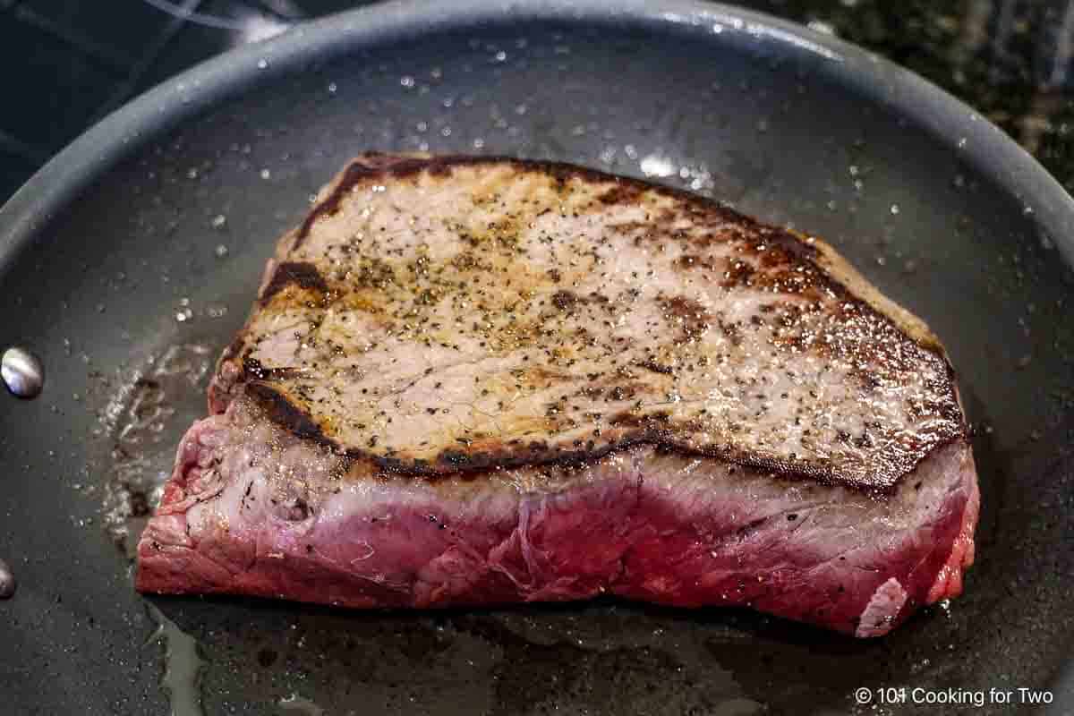 Searing chuck roast in a skillet.