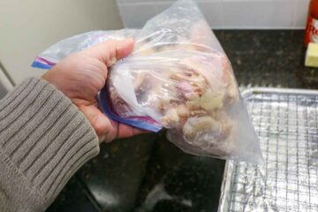 Shaking the wings in bag to coat with seasoning.