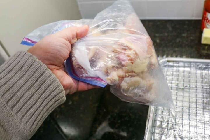 Shaking the wings in bag to coat with seasoning.