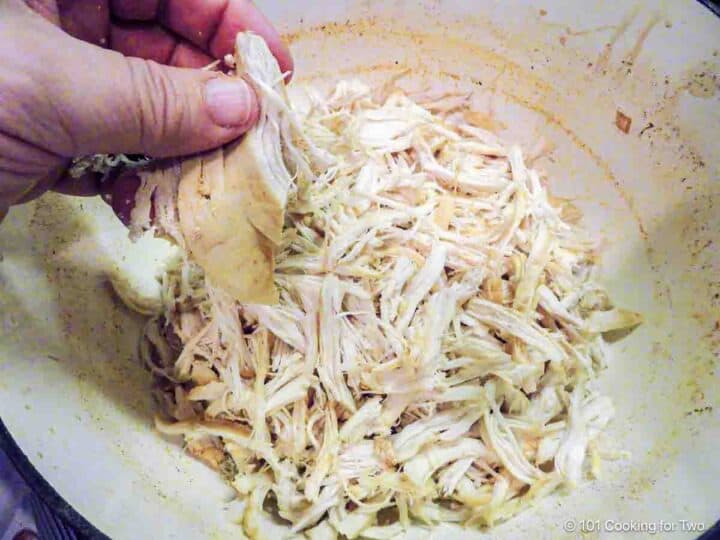 Shredding chicken by hand.