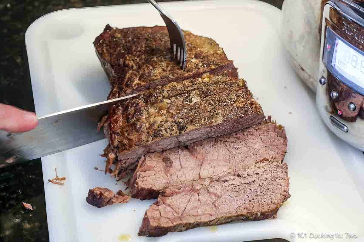 Slicing the beef roast across the grain.