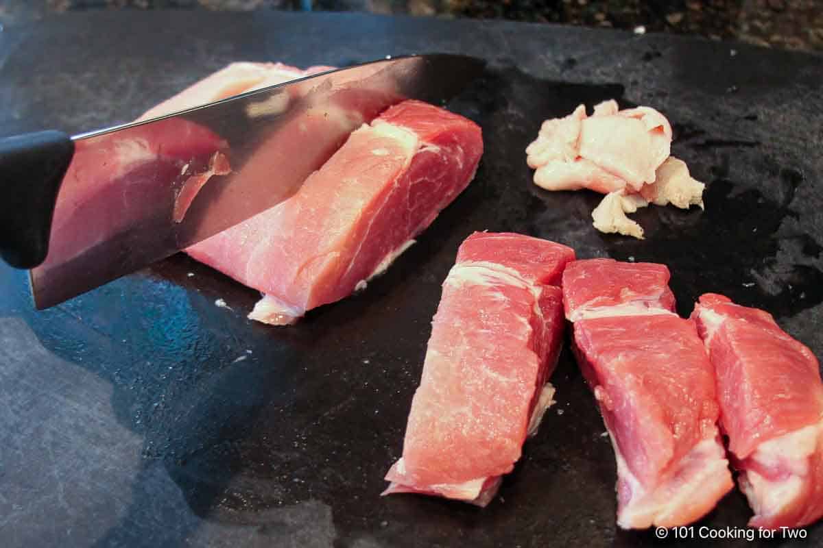 Trimming boneless ribs into individual ribs.