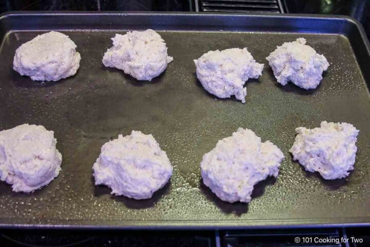 Uncooked drop biscuits on a tray.