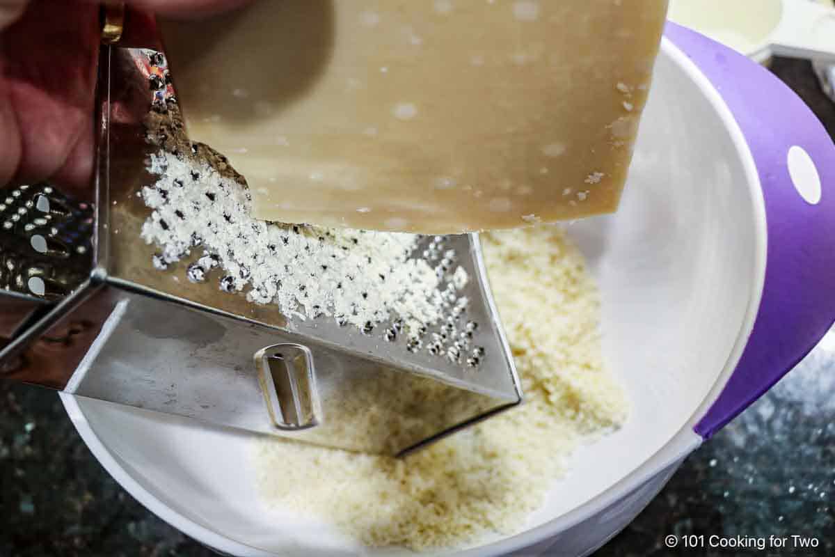 Grating Parmesan cheese into a bowl.