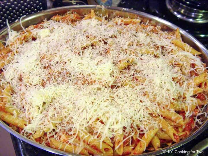 mixing sauce into the cooked pasta.