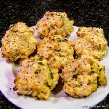 A plate full of cheddar bay biscuits.