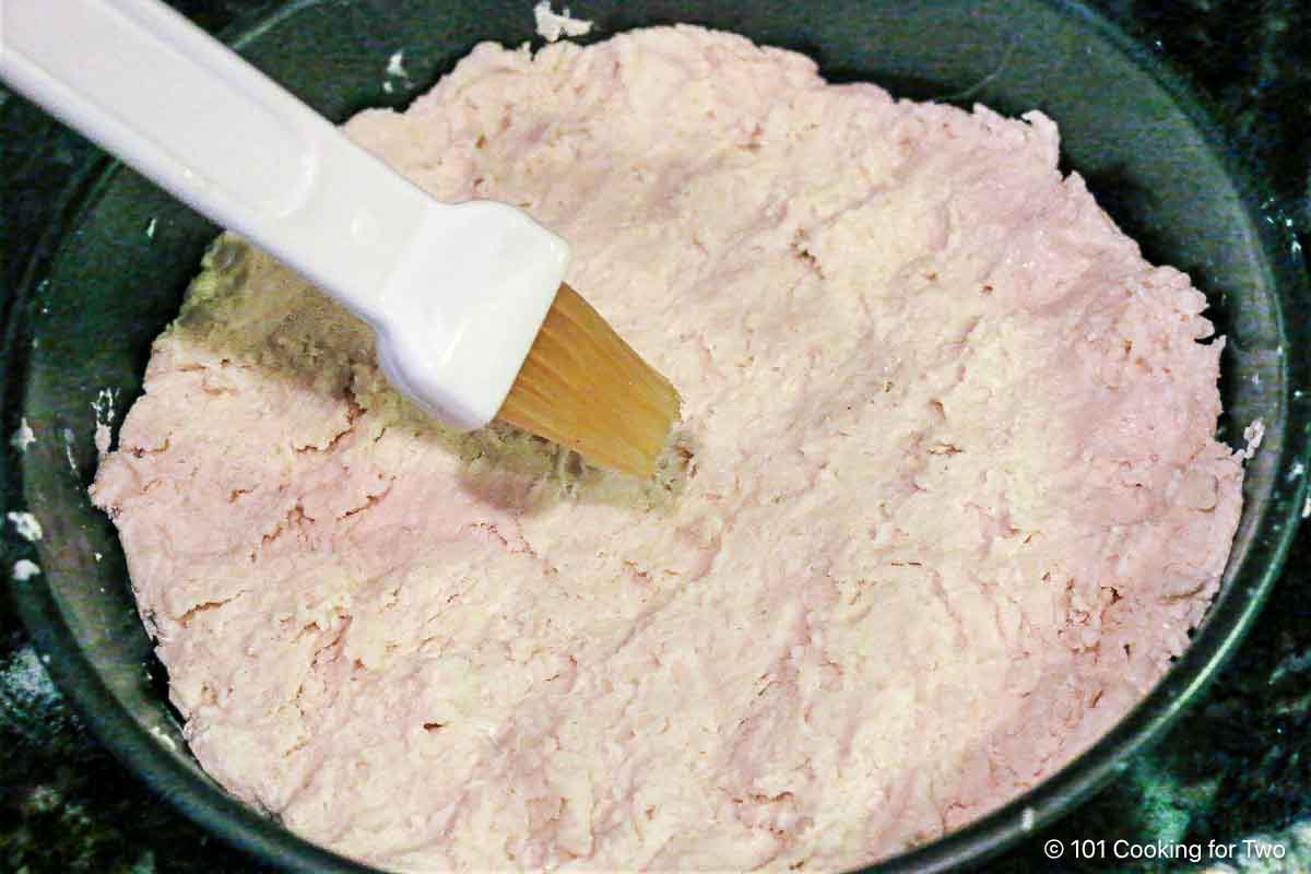 Brushing made out biscuit crust with butter.