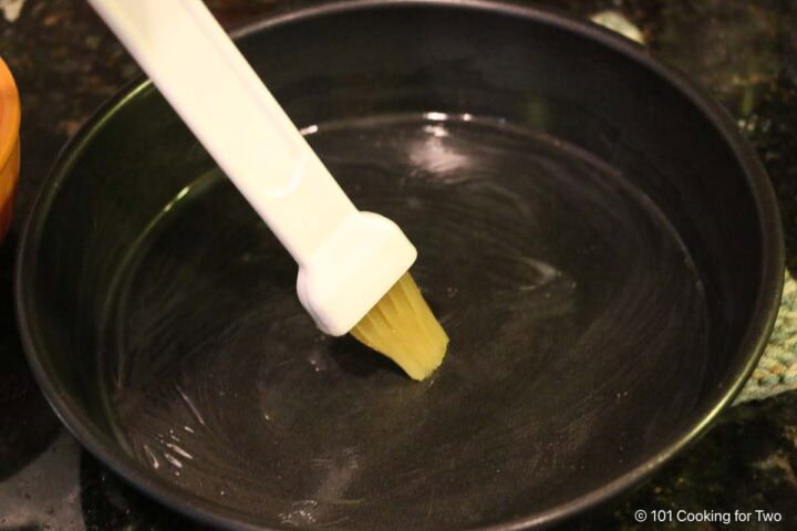 Brushing pan with melted butter.