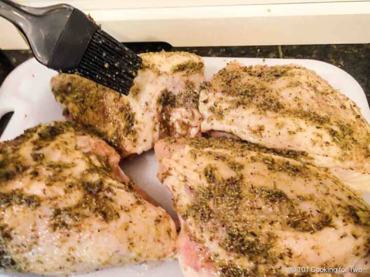 Brushing seasoning on the chicken.