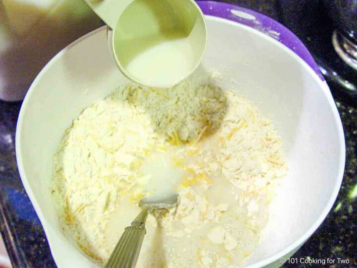 Mixing buttermilk into the dry dough ingredients.