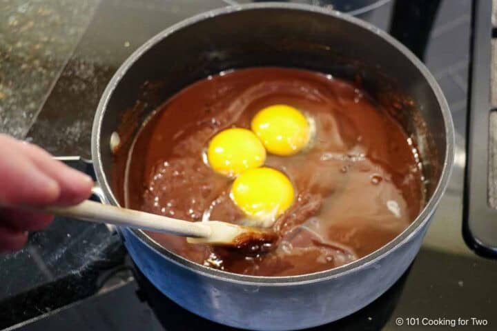 Mixing eggs into the batter.