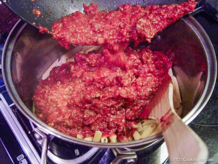 Mixing the meat sauce into the cooked pasta