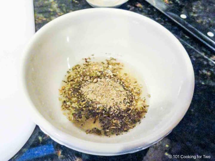 Mixing Herbs de Provence seasoning with olive oil and lemon juice.